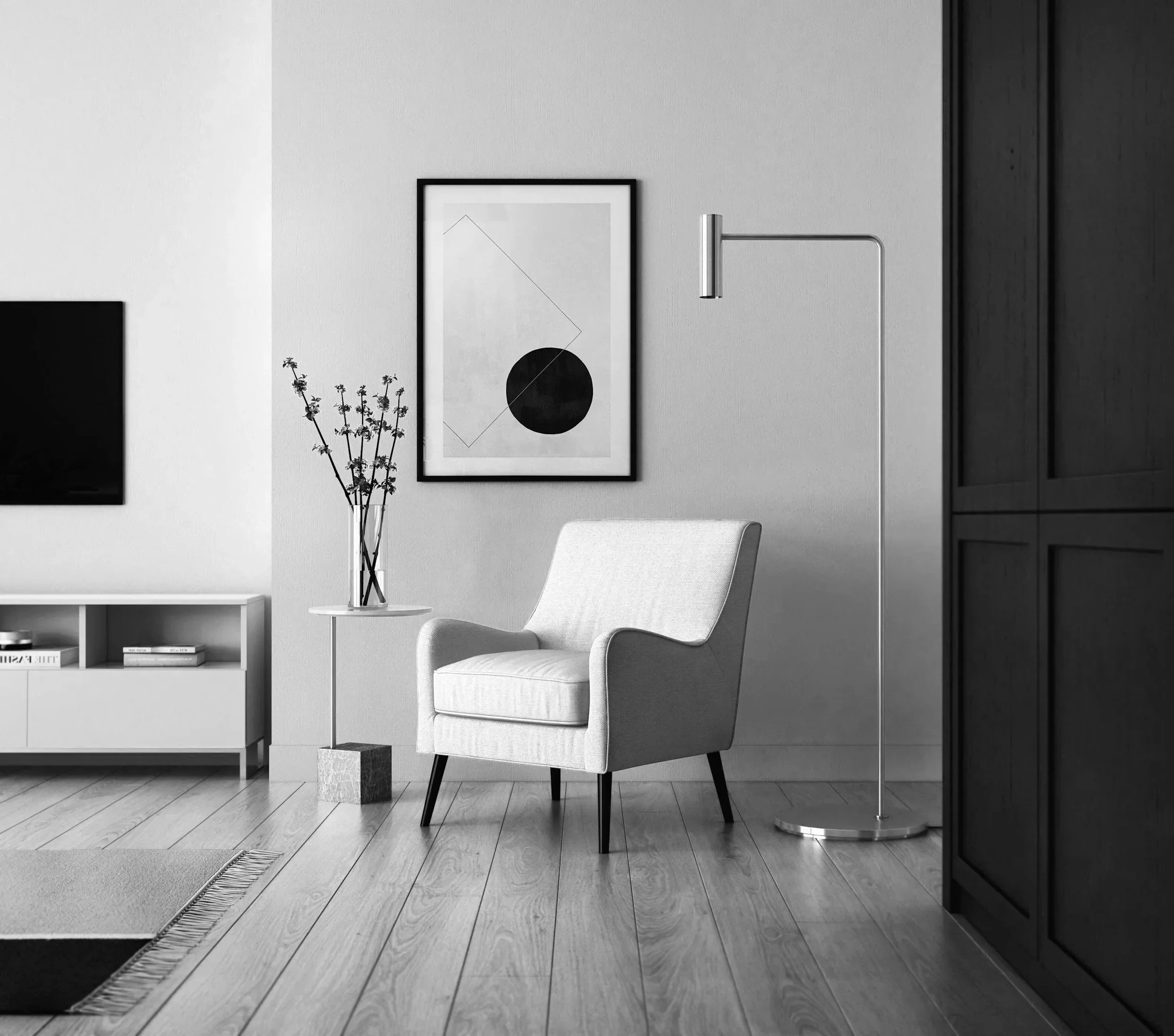 Living room with a white armchair, a small side table with a vase of flowers, a framed abstract art piece, a tall floor lamp, a television on a TV stand, and a black wardrobe in the corner.