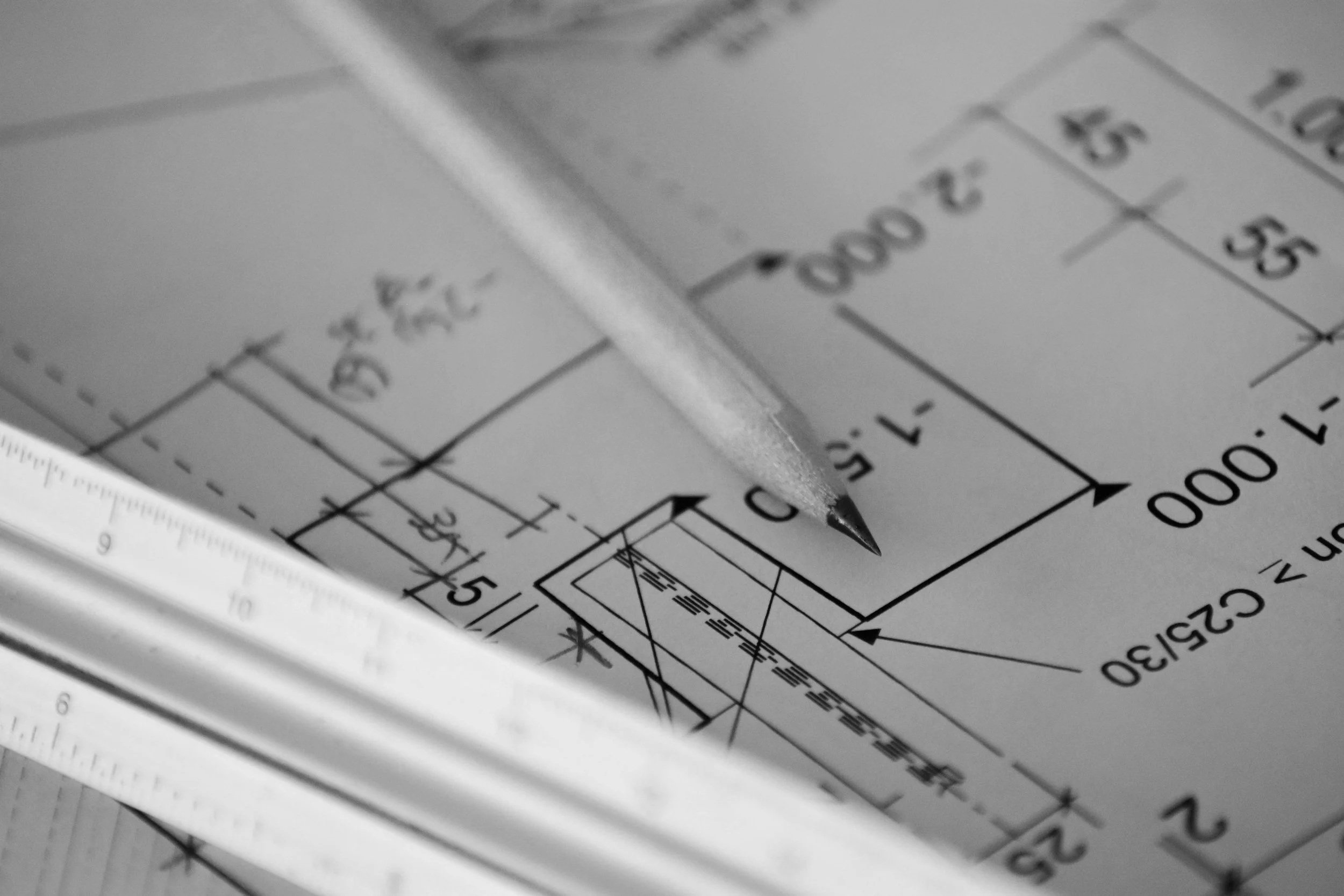 Open-concept kitchen and living room with dining table, kitchen island, refrigerator, and sofa, decorated with framed artwork and plants.