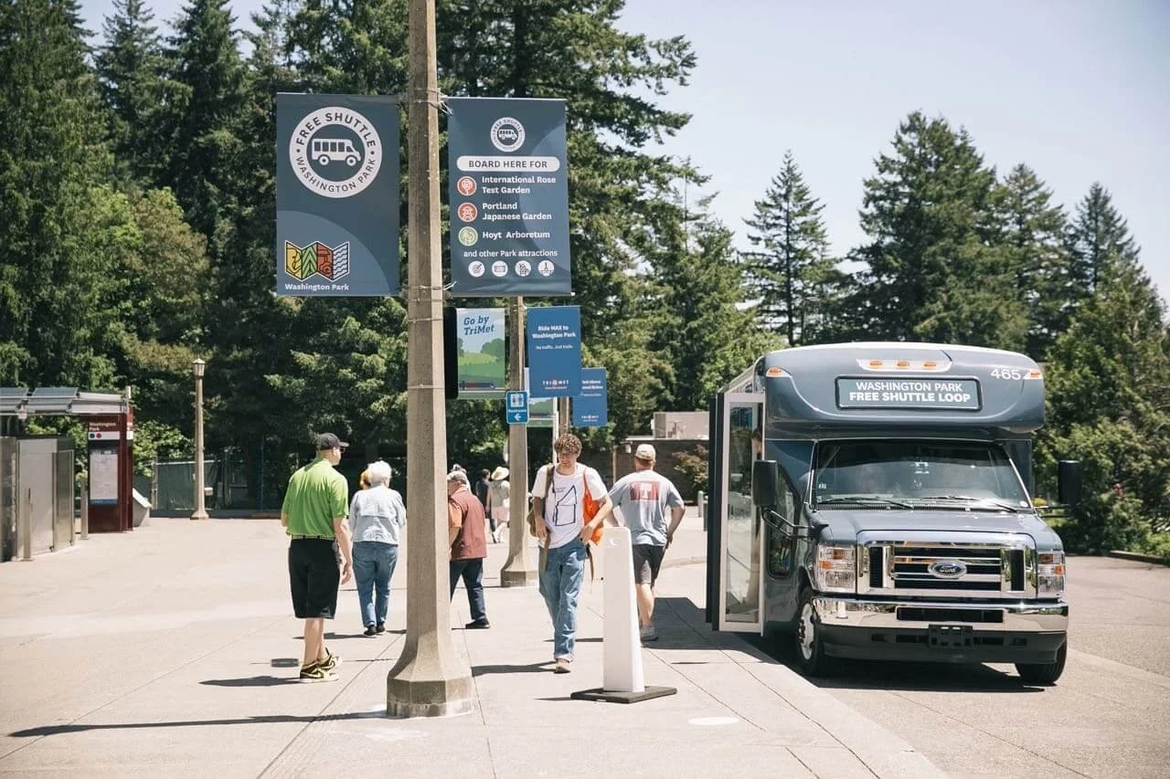 Visitors boarding the Washington Park Free Shuttle Loop bus near a TriMet transit stop