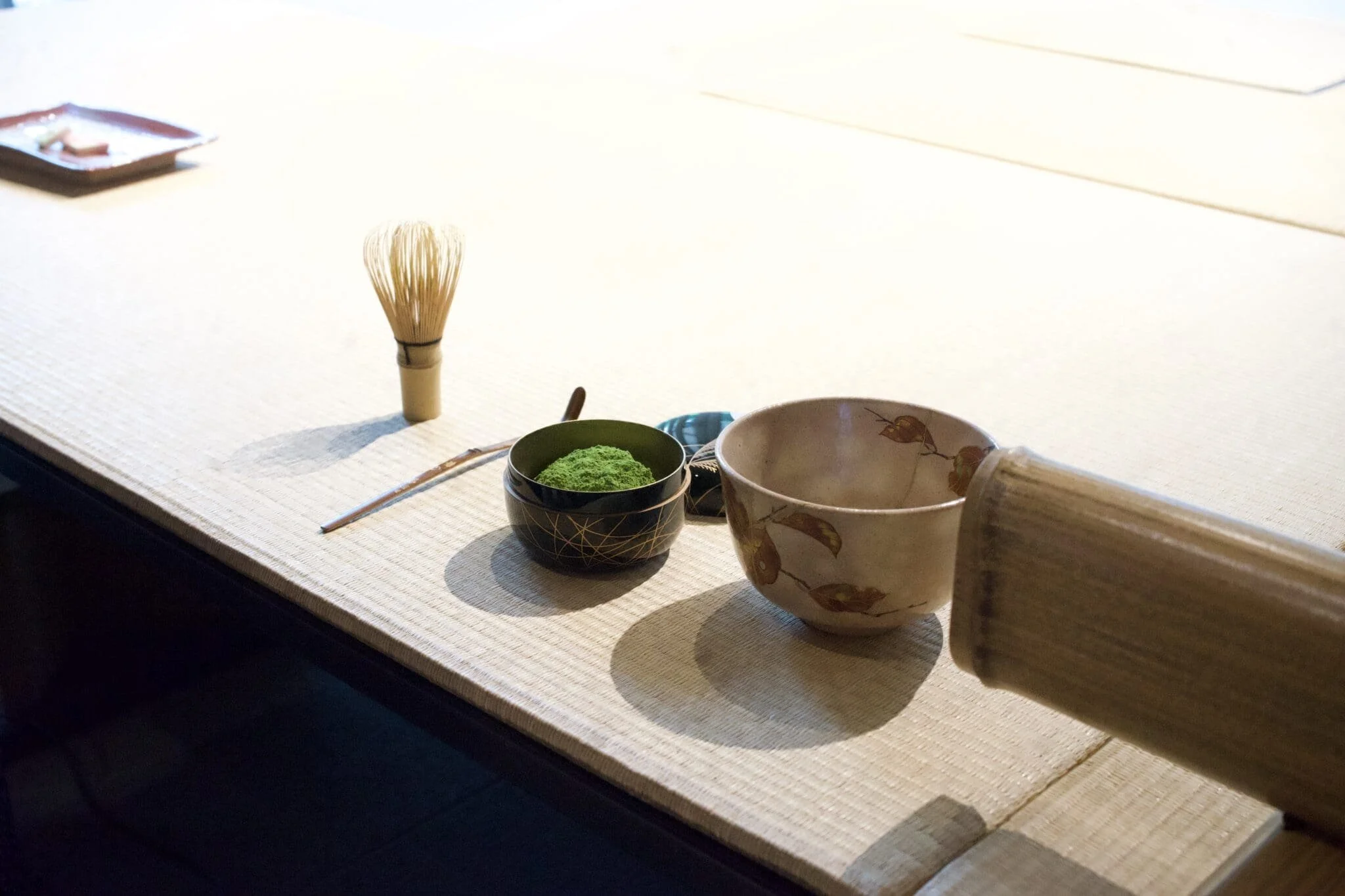  Traditional tea utensils—a matcha bowl, bamboo whisk, and kettle—arranged for the ceremony. 