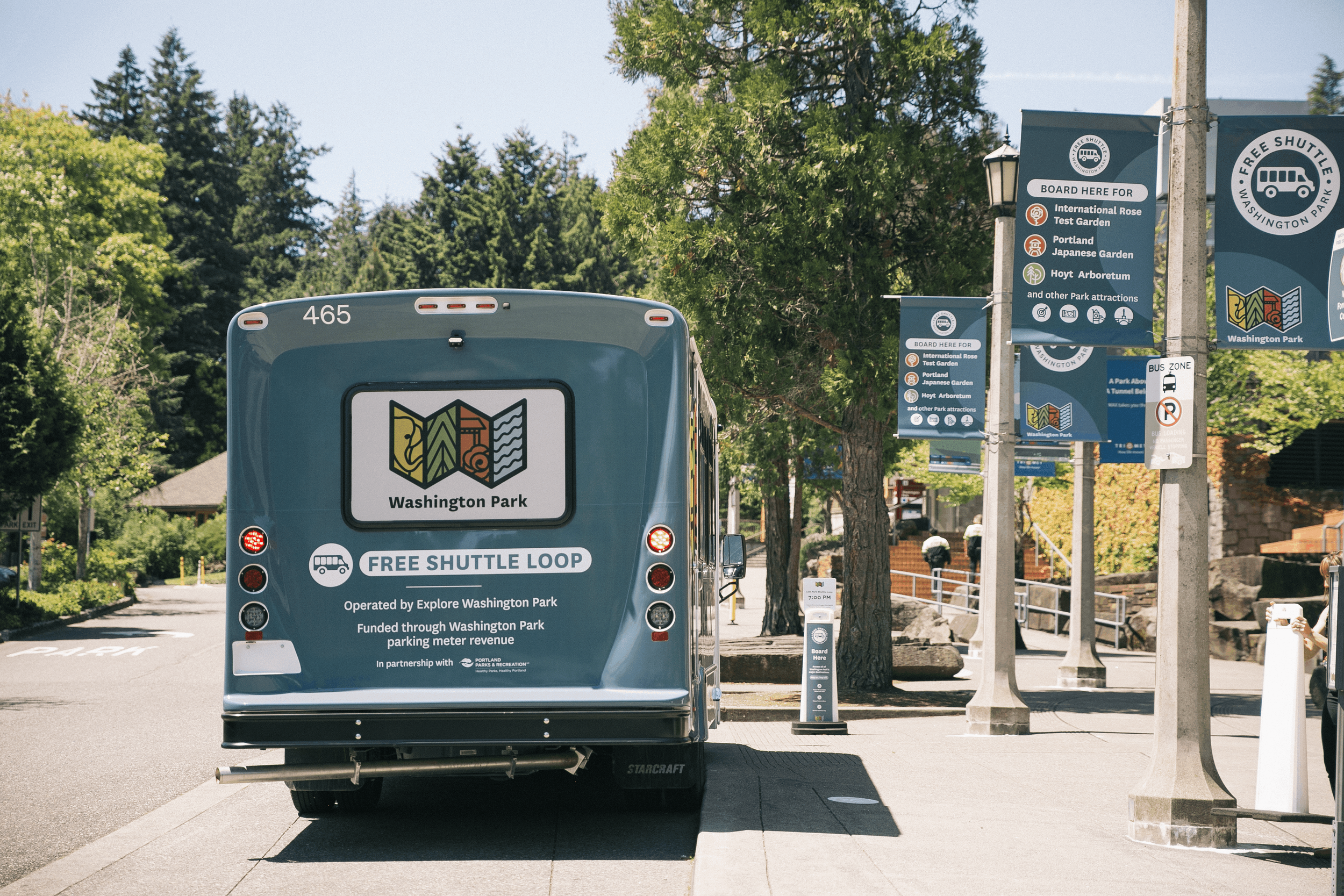 The back of the Washington Park Free Shuttle Loop bus parked at a stop, next to common questions about the shuttle.
