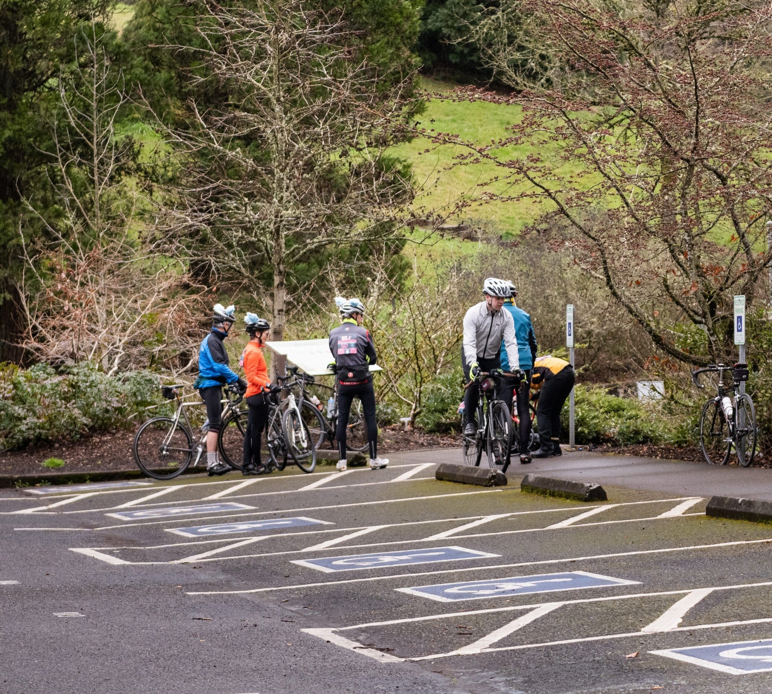 A group of cyclists in gear stop at a park intersection during a ride through Washington Park
