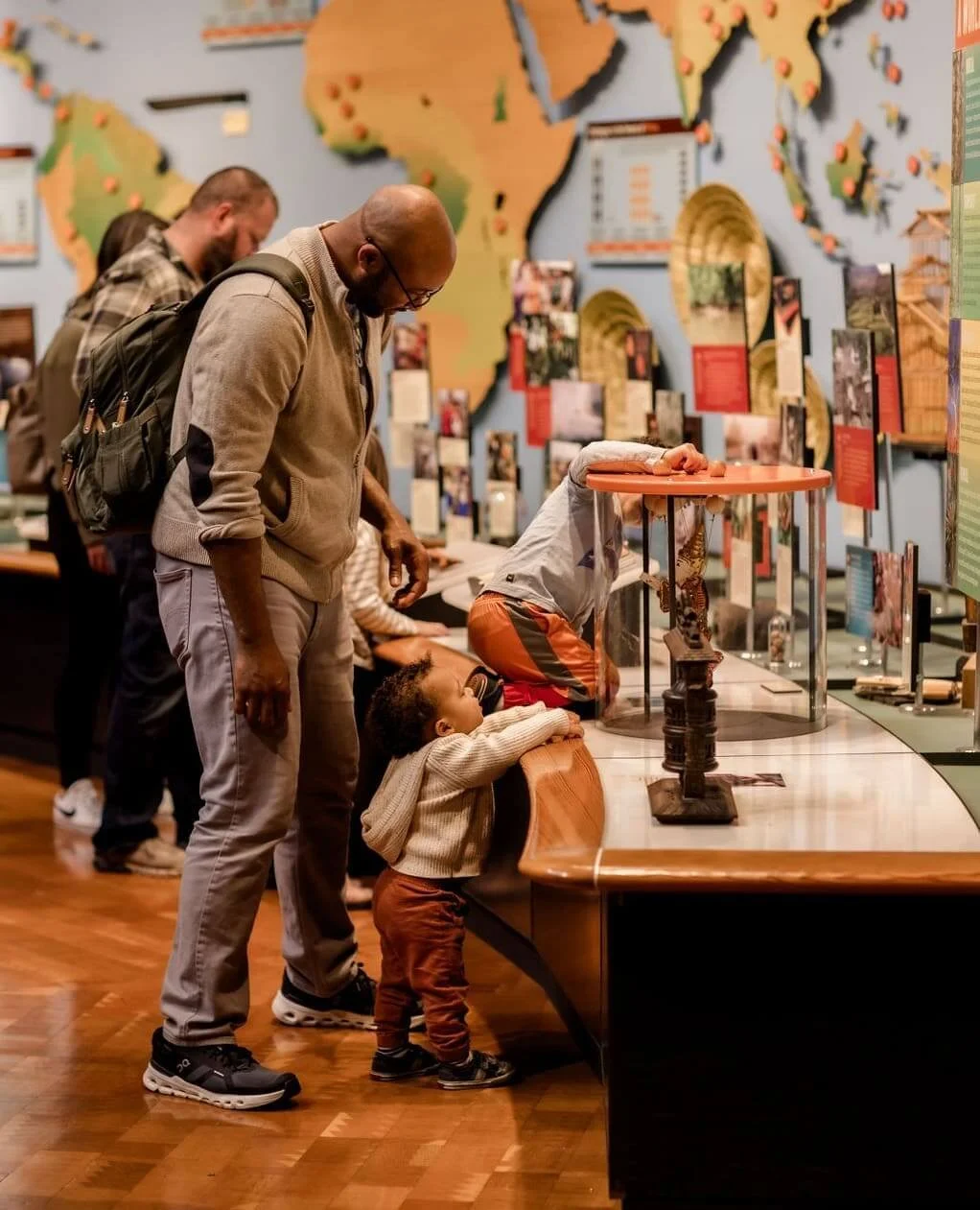 Families with young children explore display cases during a free community day at the World Forestry Center Discovery Museum
