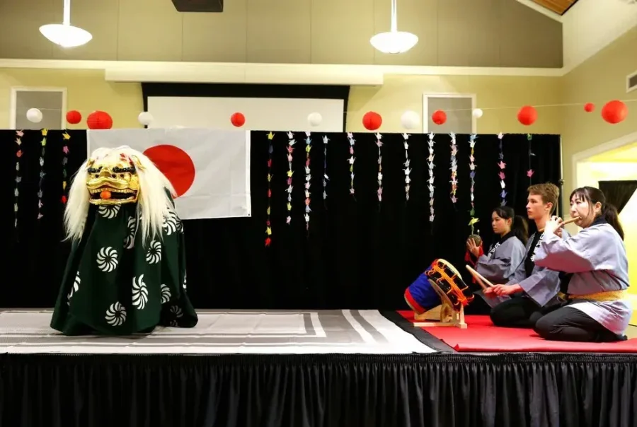 Performers present the Edo Kotobuki lion dance to a seated audience at Portland Japanese Garden.
