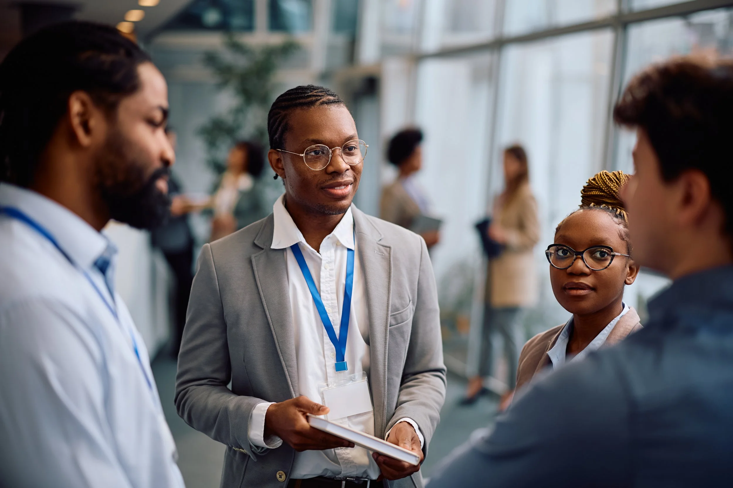 People in a professional setting having a conversation at an event or conference.