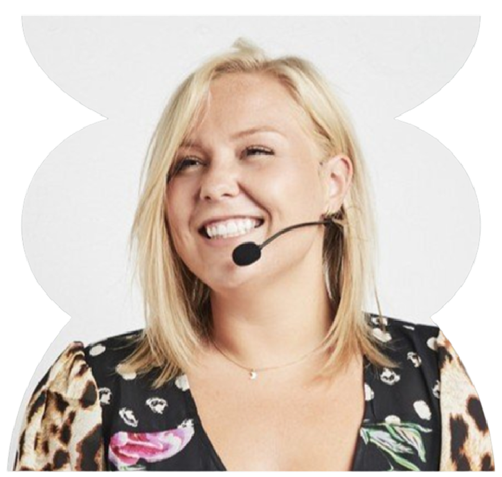 Smiling woman with blonde hair wearing a microphone headset, black floral and leopard print top, against a white background.