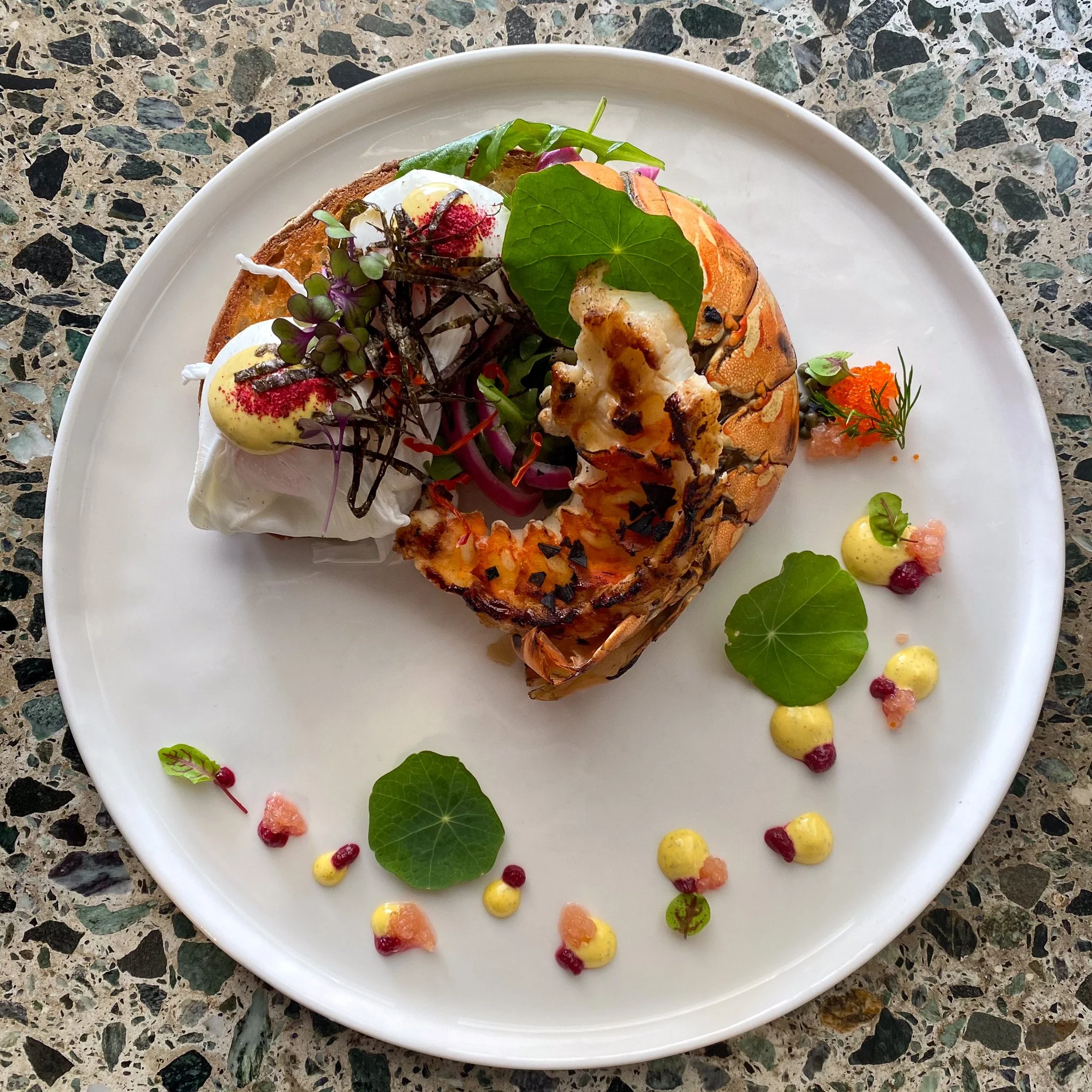 plate of painted crayfish eggs benedict