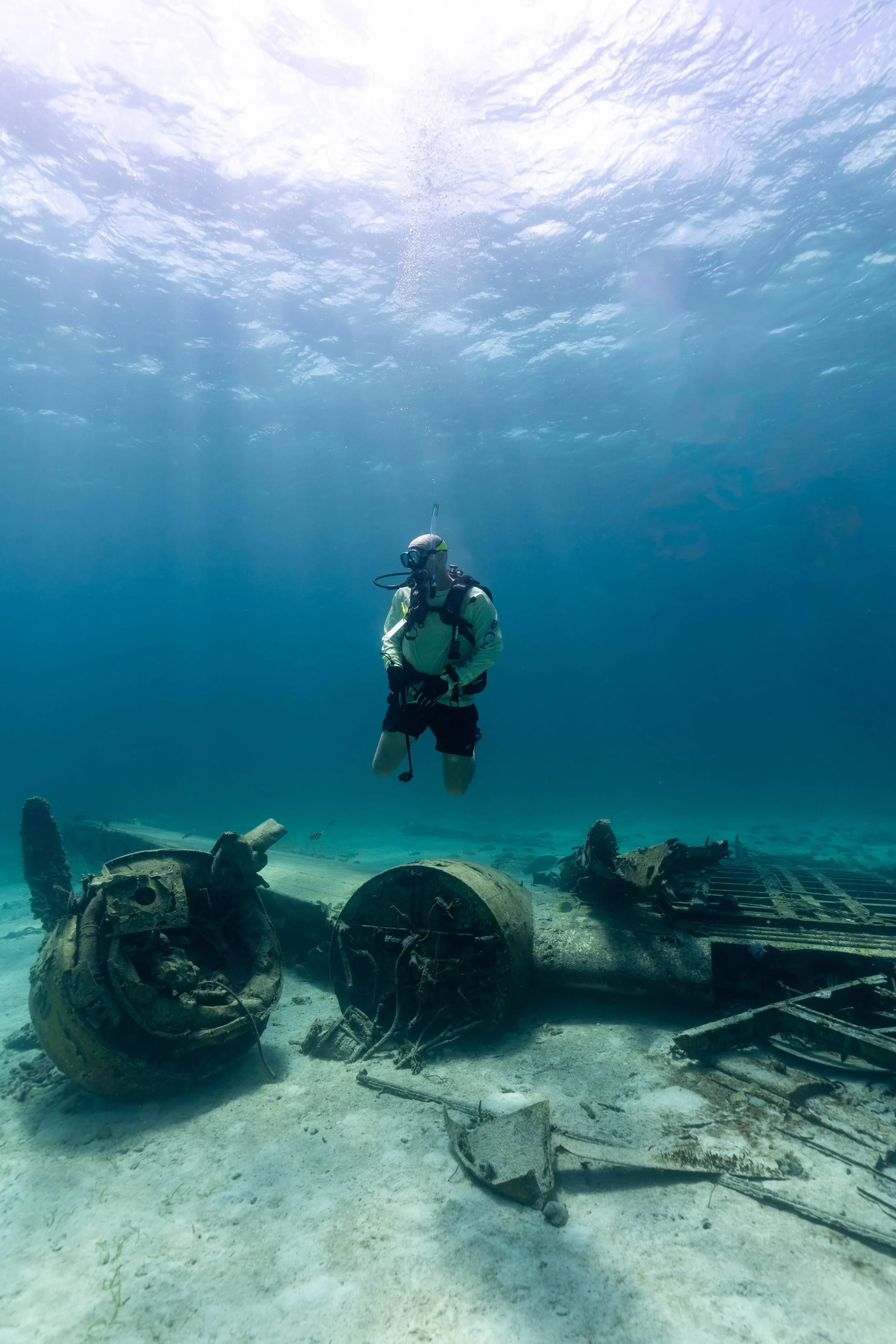 Man scuba diving over top of ship wreck