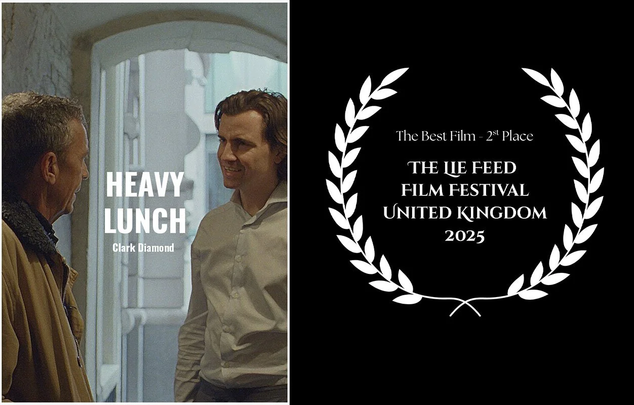 A film poster for 'Heavy Lunch' featuring two men talking inside a building, with one wearing a tan coat and the other in a white shirt, and an award laurel for 2nd place at the 2025 UK film festival.