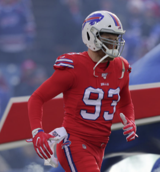American football player in red uniform with the number 93, wearing a helmet and gloves, on the field.