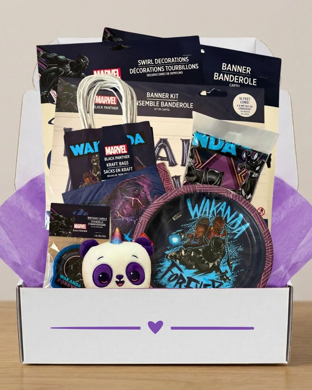 A Marvel Black Panther themed gift box containing party supplies, a plush panda toy, and purple tissue paper.