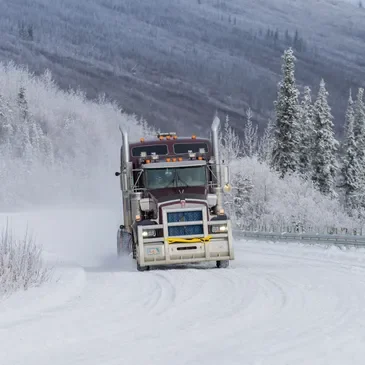 Truck hualing down road.webp