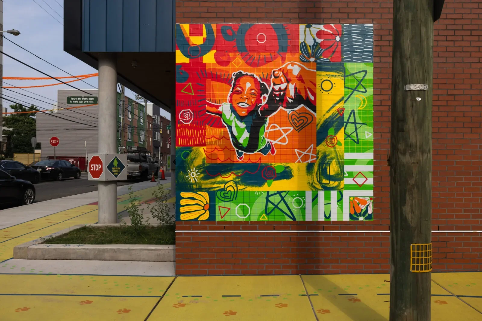 Mural Arts Philadelphia participated in the Live and Learn pilot project in Sharswood by creating the Run the Road mural, which was completed in June 2025. This combined wall and ground mural, part of Live and Learn’s playful learning initiative, aim