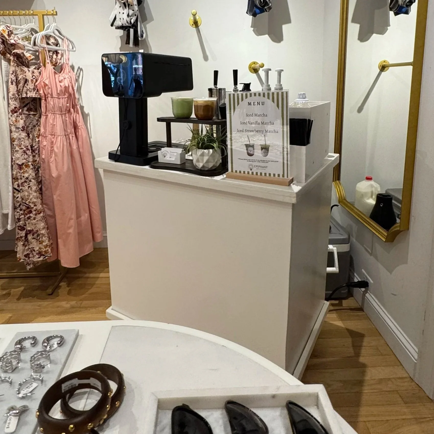 Display of jewelry on a white table including various rings and bracelets, with a shoe visible in the foreground.