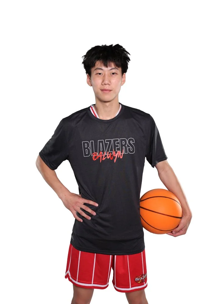 Young man in basketball uniform holding a basketball against a white background.