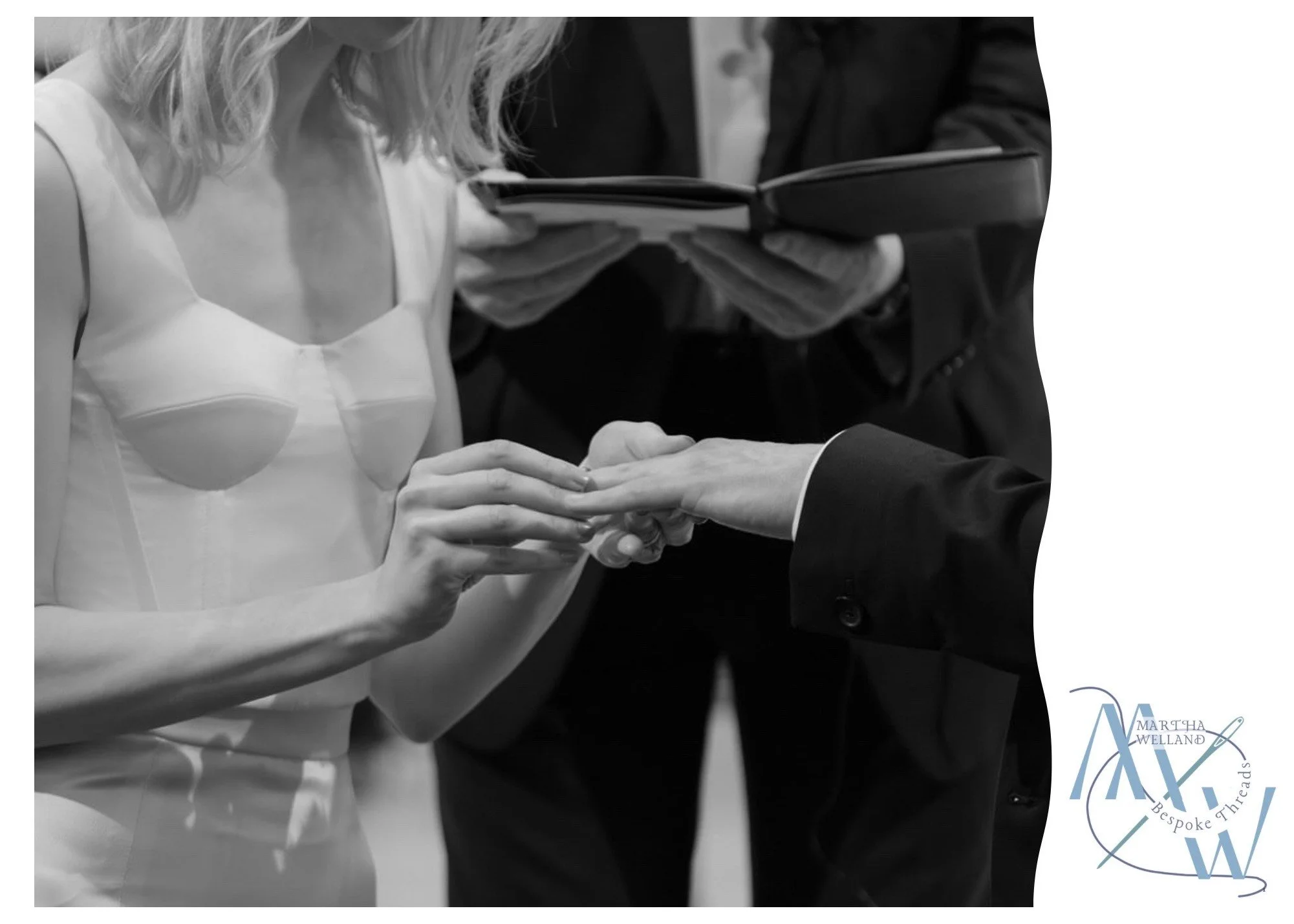 Person placing a wedding ring on another person's finger during a wedding ceremony, with officiant holding a book in the background.