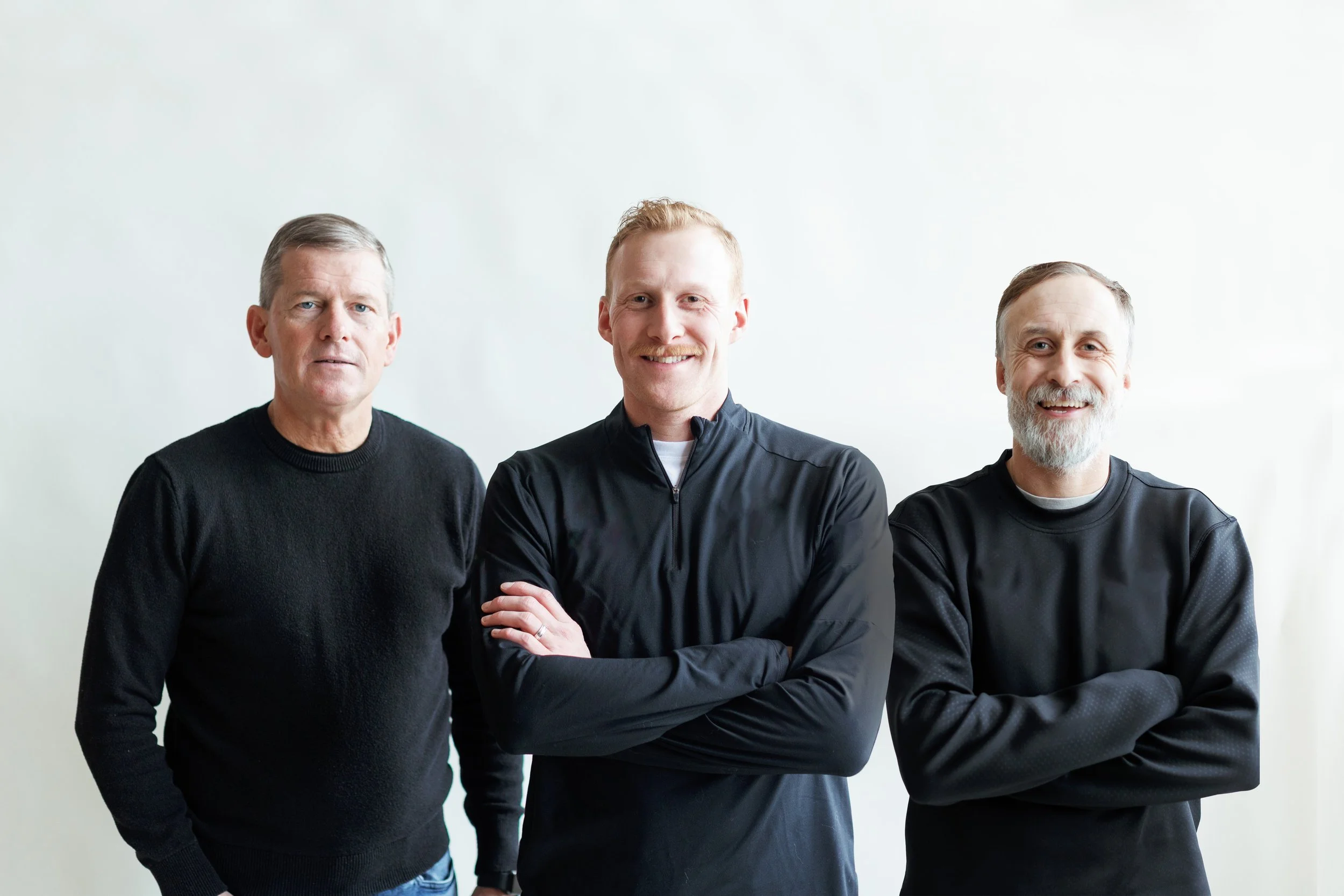 3 men in black smiling