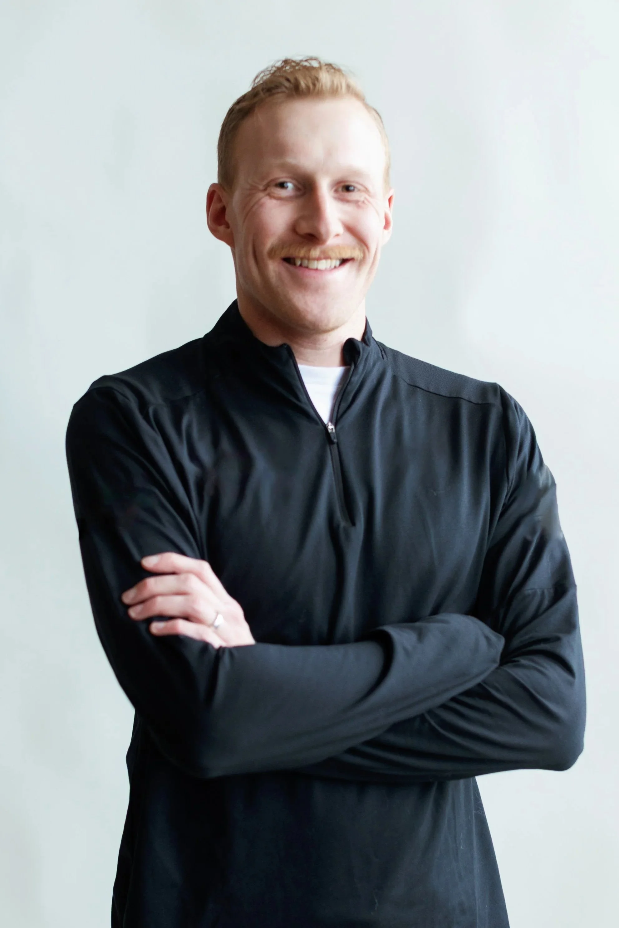 A smiling man wearing a quarter-zip