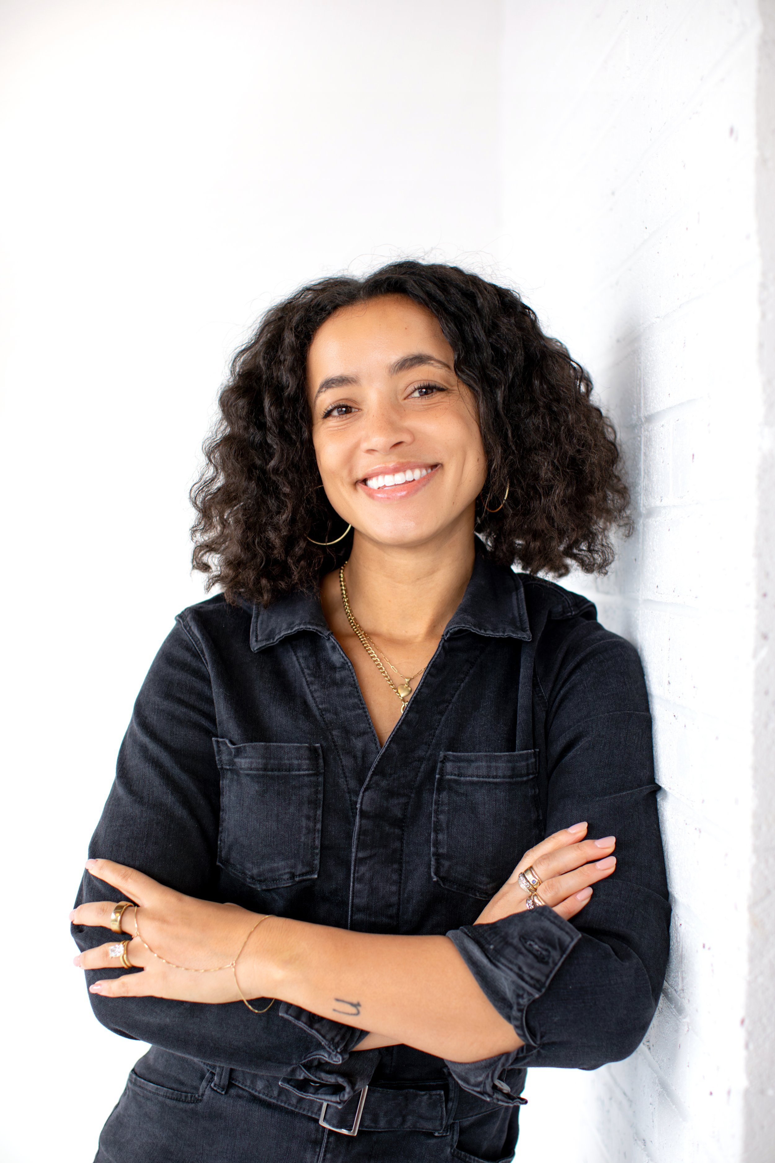 Two people sitting at a table, looking at their laptops, engaged in a discussion or meeting, with a window in the background.
