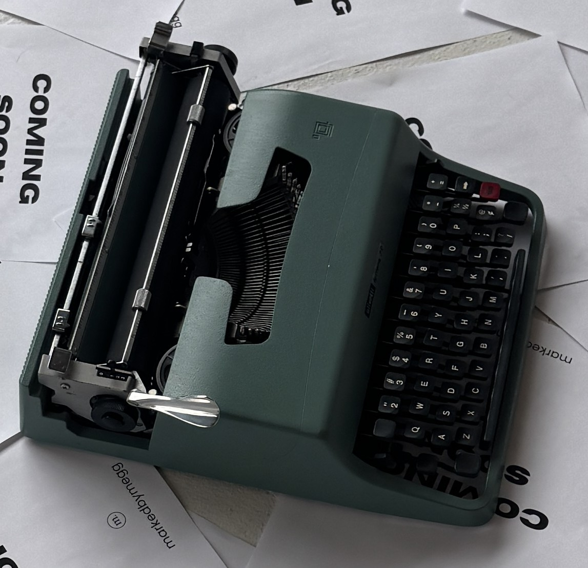 A woman with short black hair, wearing a white top, black pants, and a blue denim jacket, smiling and looking joyful.