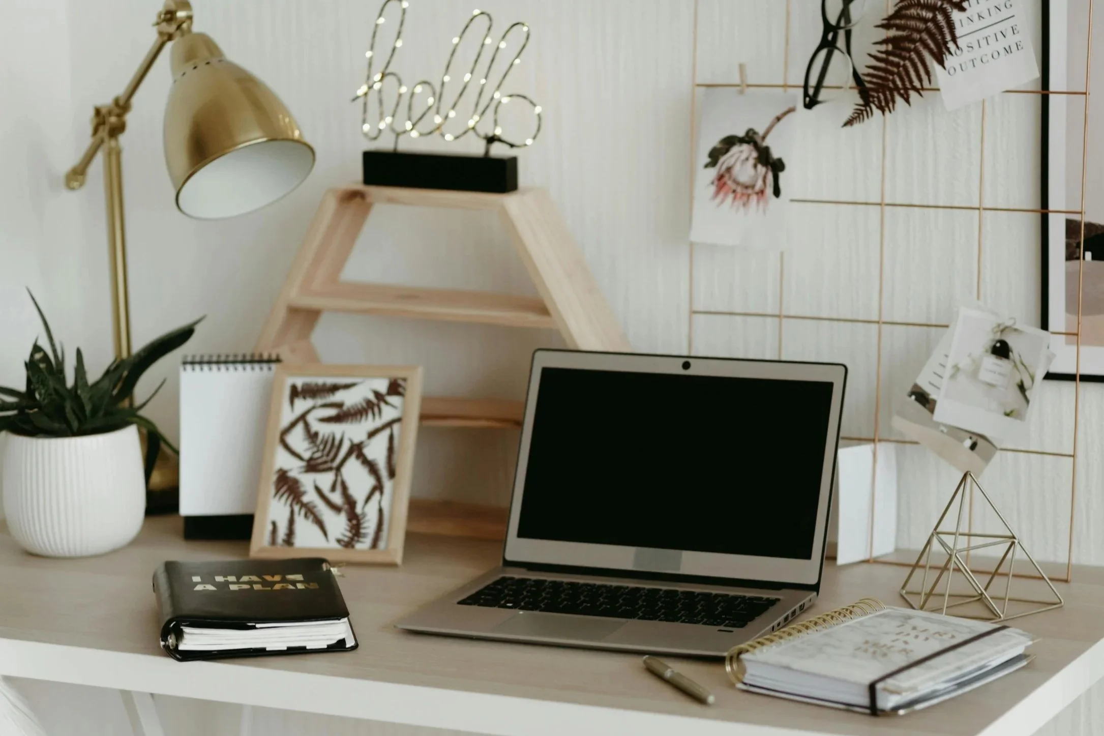 Desk with lamp, hello sign, and computer