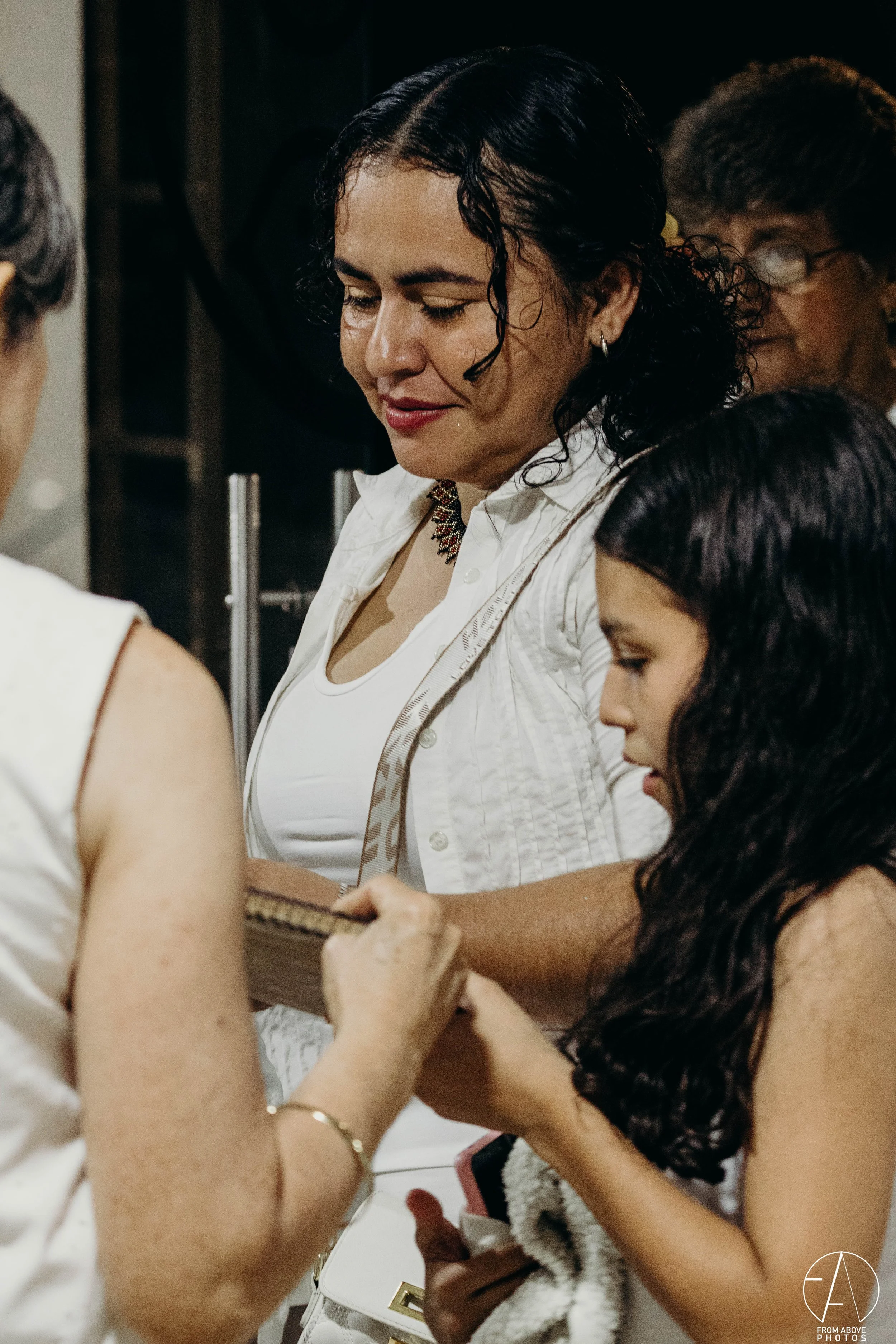 Grupo de mujeres en una reunión, una de ellas muestra un libro a las demás.