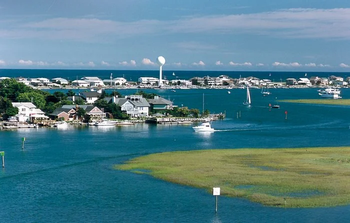Wrightsville Beach offers scenic views of coastal waters, houses, boats, and sailboats.