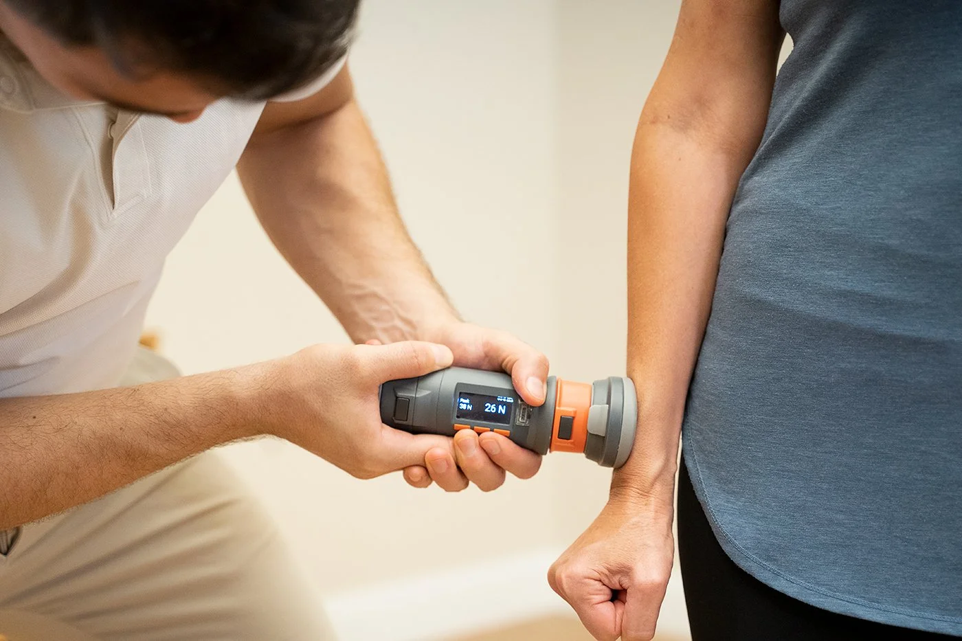 A healthcare professional uses a handheld device on a patient's wrist for a medical checkup.