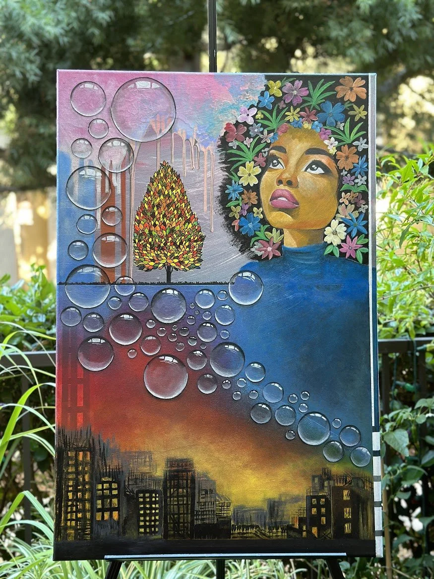 “This multi-layered artwork bridges urban energy with inner reflection. Transparent bubbles rise from a glowing city at dusk, passing a lone tree and dissolving into a sky filled with color. The woman’s floral crown and thoughtful expression evoke th