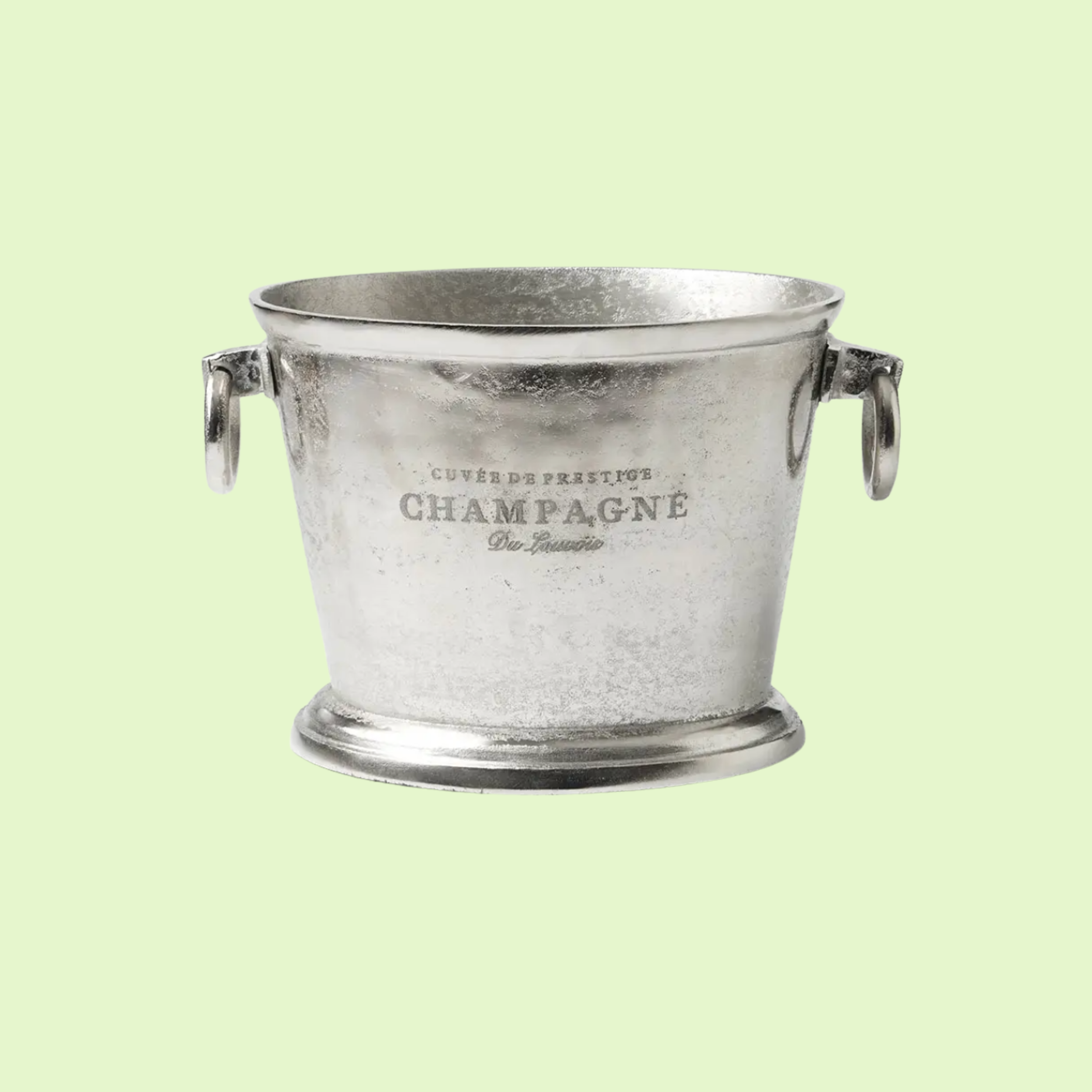 Silver champagne bucket with engraved French text, set against a light green background.