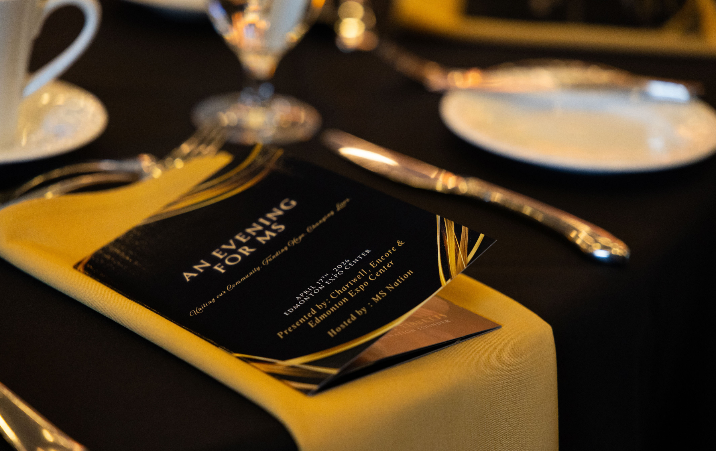 An Evening for MS 2026 gala invitation and table setting at Edmonton Expo Centre