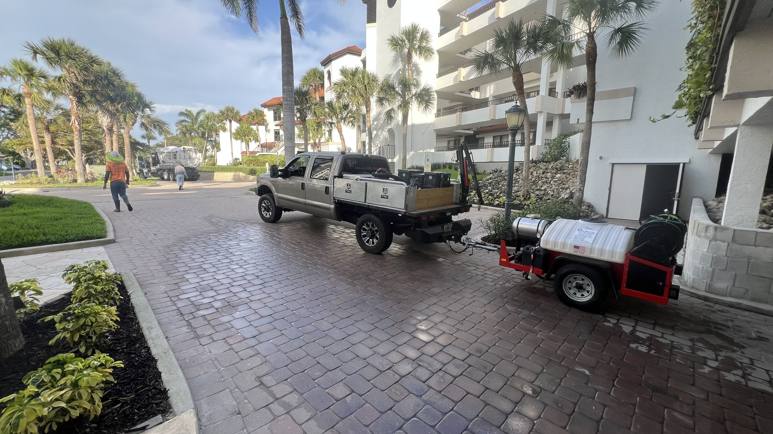 Stormwater technicians with a jetting trailer performing drainage maintenance at a condominium community in Naples, Florida.