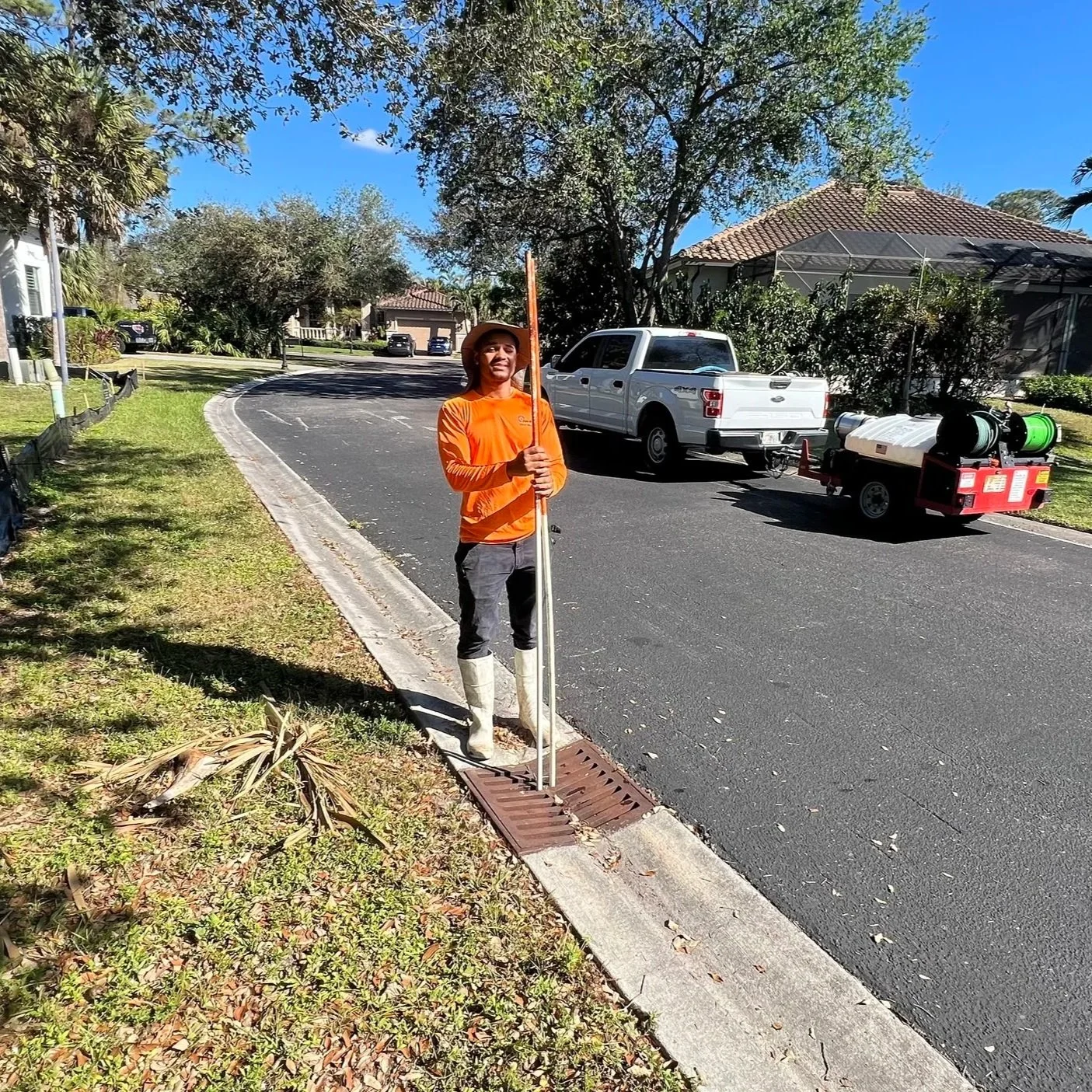 Certified stormwater inspector measuring inlet depth and documenting conditions during a community drainage inspection in Southwest Florida.