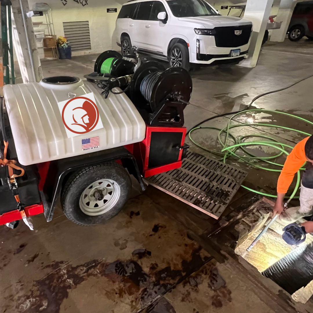 Two Tools and a Truck jetter trailer cleaning storm drain in underground garage using jetter hose