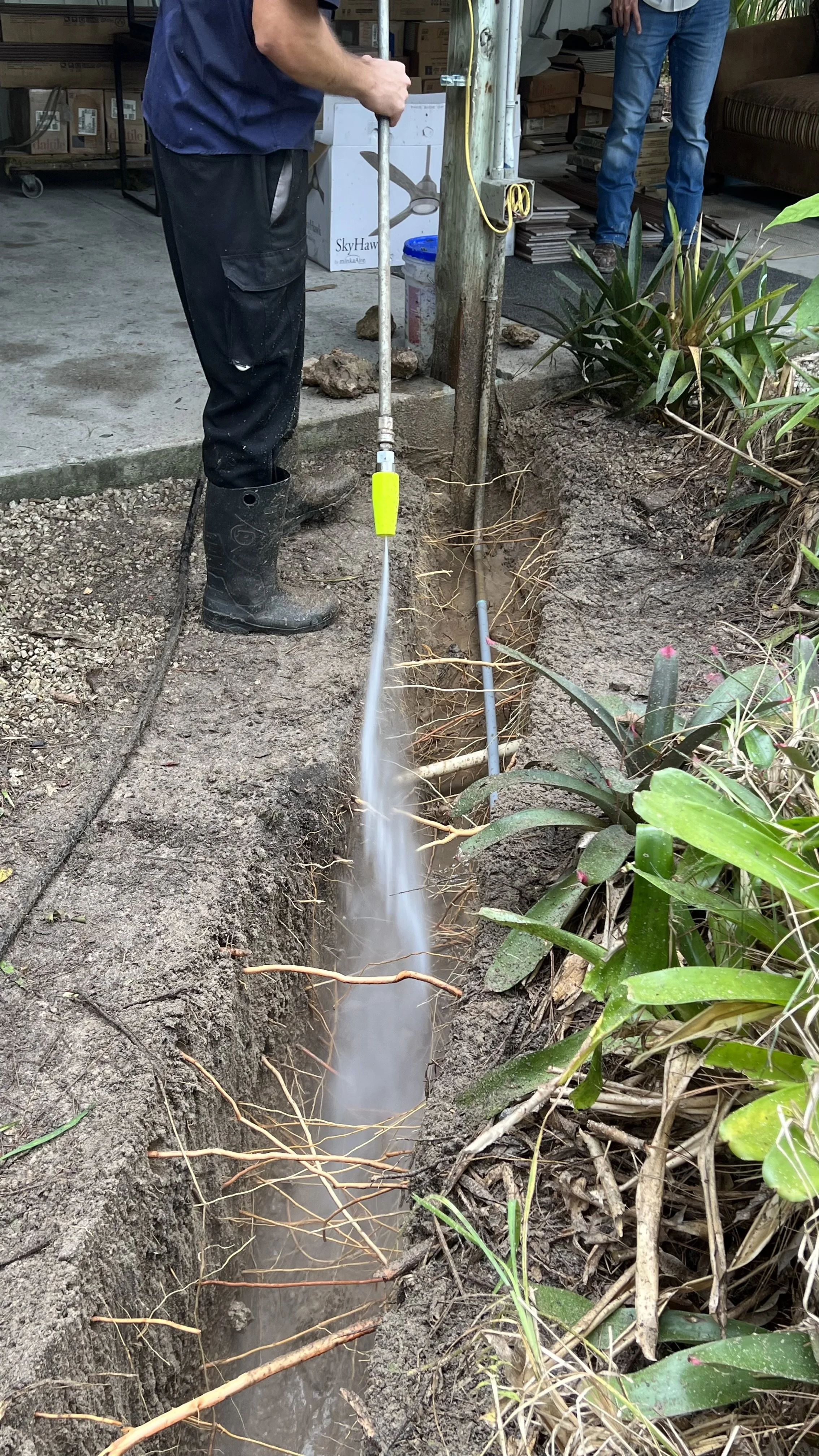 High-efficiency Dig Pig hydro excavation nozzle cutting a narrow trench to expose underground utilities in Southwest Florida.