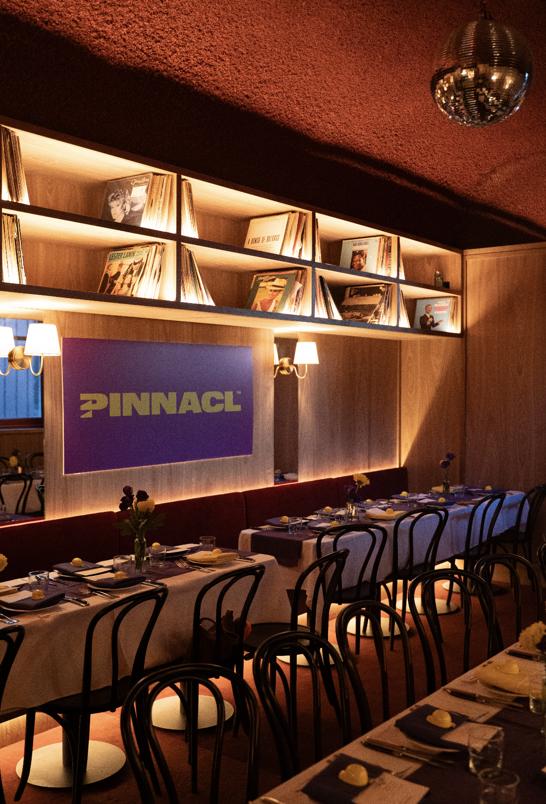 A cozy restaurant or bar with warm lighting, wooden furniture, and a disco ball hanging from the ceiling.