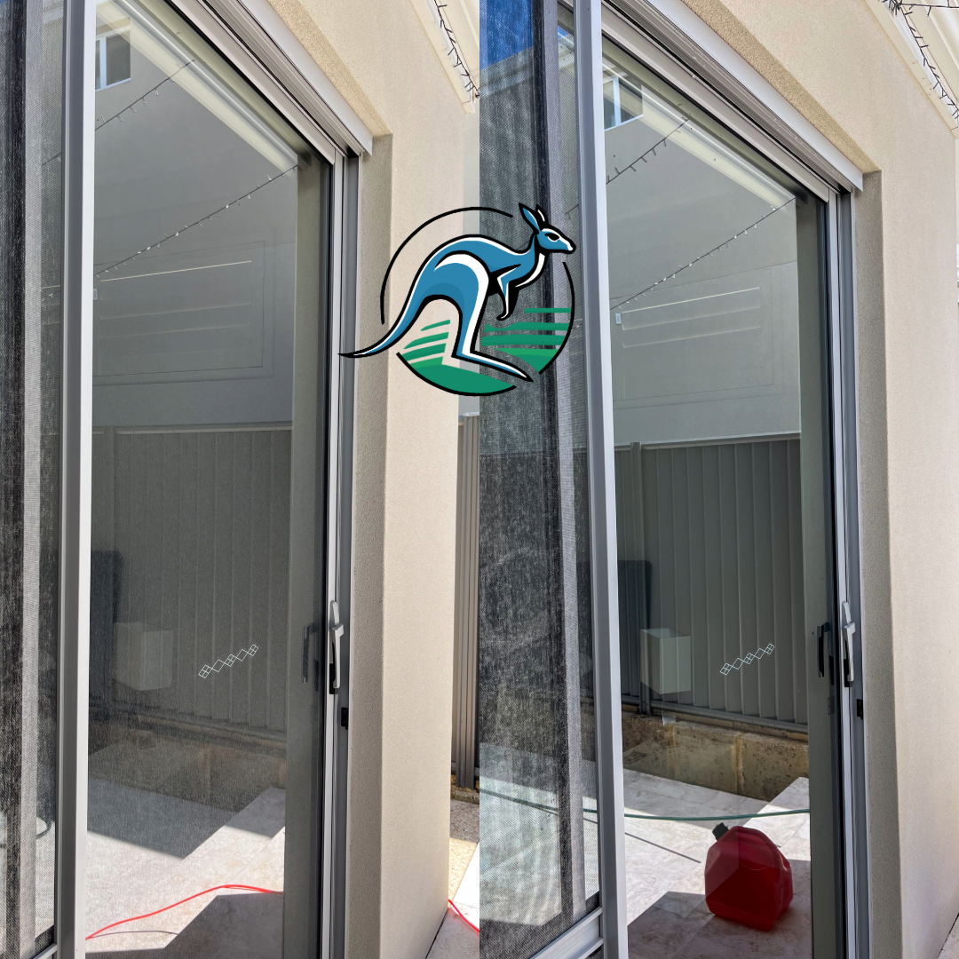 Sliding glass door leading to an outdoor area with a beige wall, string lights, and a gray fence; some construction materials are visible inside.