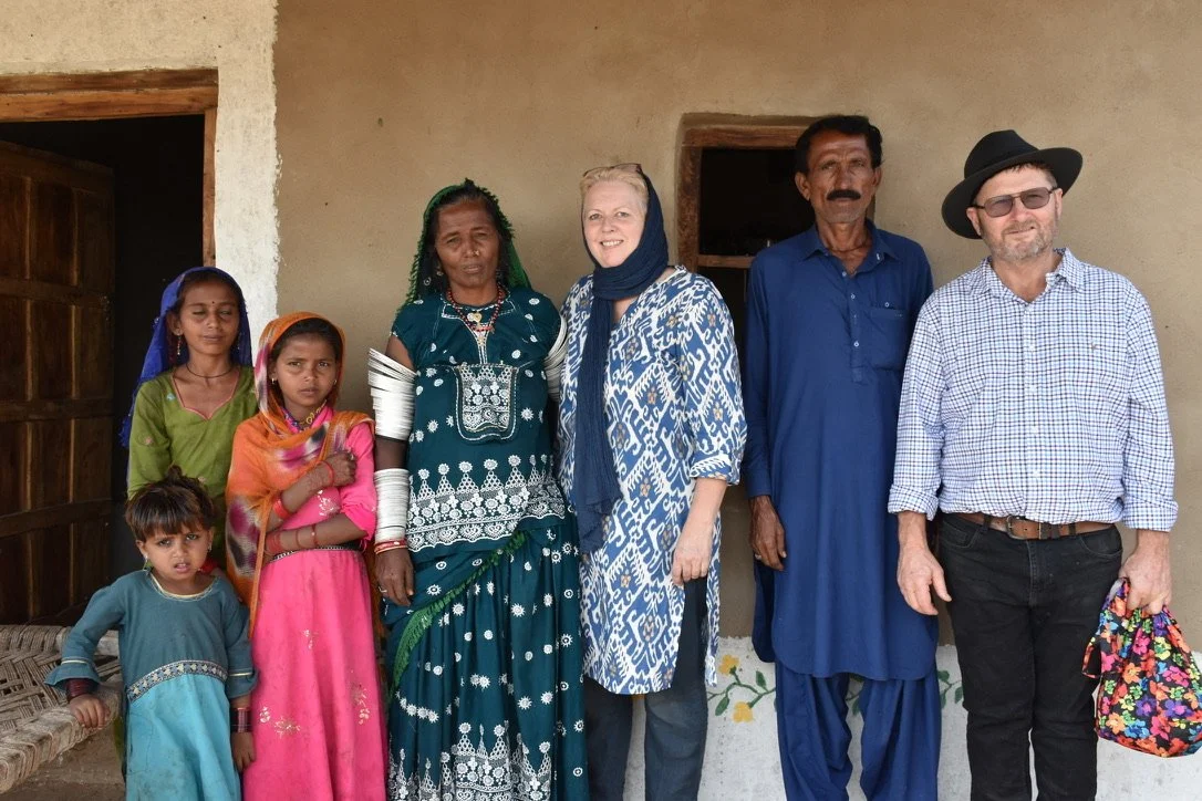 WakeUp 121 charity team with pakistani christian family in traditional clothing during rural outreach visit