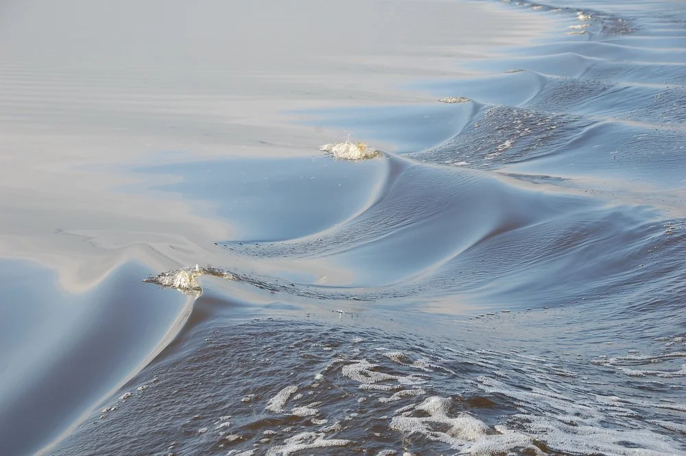 Close-up of ocean waves with ripples and foam.