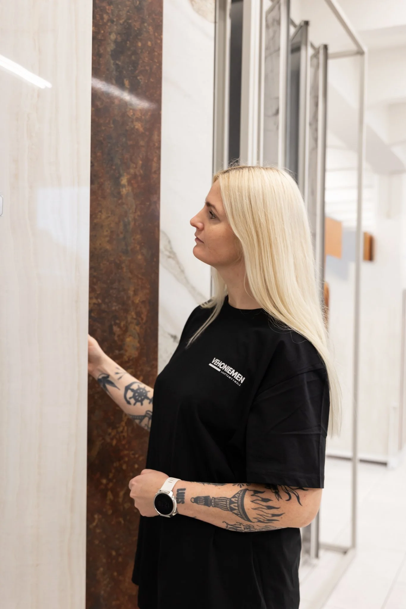 Nainen katselee tiili- ja marmorialtaita kiviosastossa myymälässä.