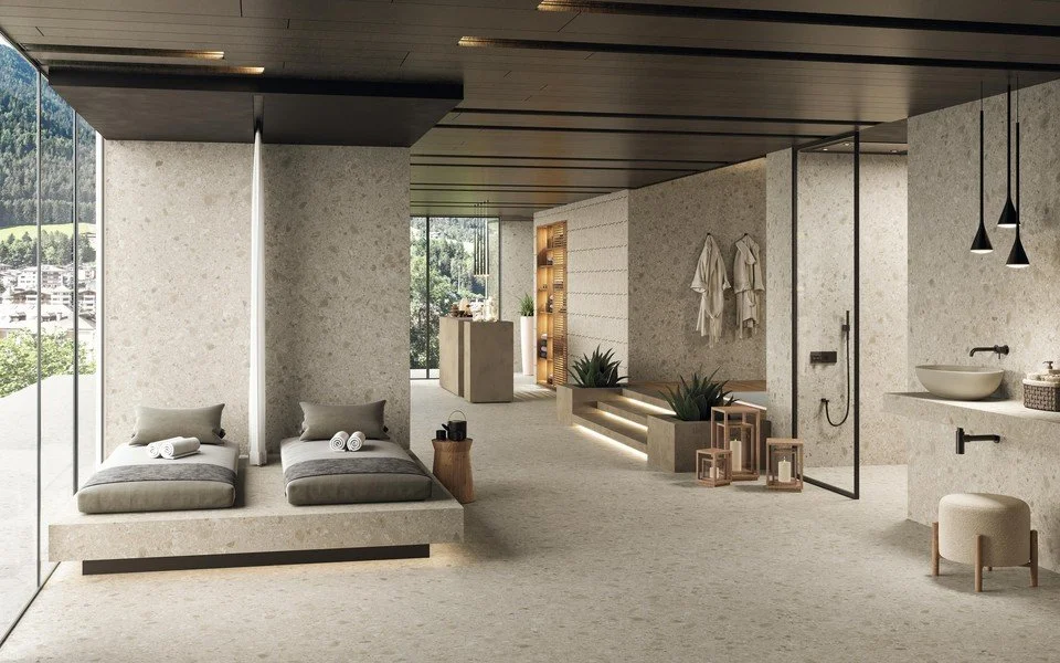 Beigen sävyinen spa ja kylpyhuone, jossa suihkut ja käsienpesualtaat.