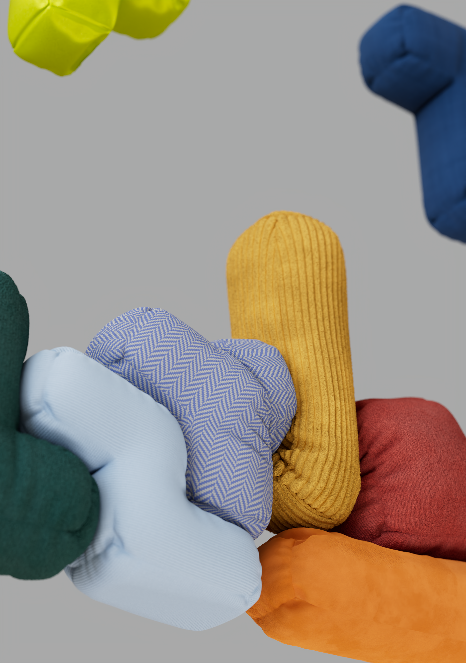 Un montaggio di cuscini colorati di varie forme e tessuti disposti su un piano grigio.