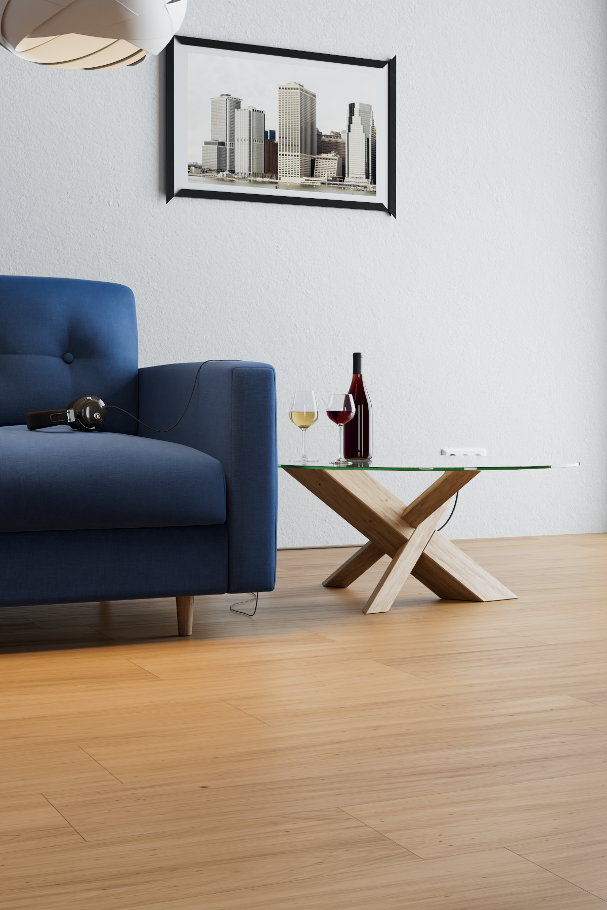 Interno di un soggiorno con un divano blu, un tavolino in legno con piano in vetro, e un quadro di edifici sulla parete bianca.