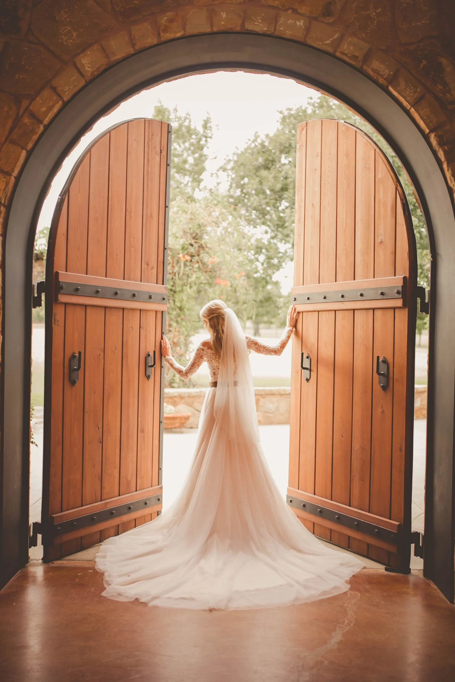 Dramatic open wooden doors to frame a bride at Bella Vita Ranch, Texas wedding venue