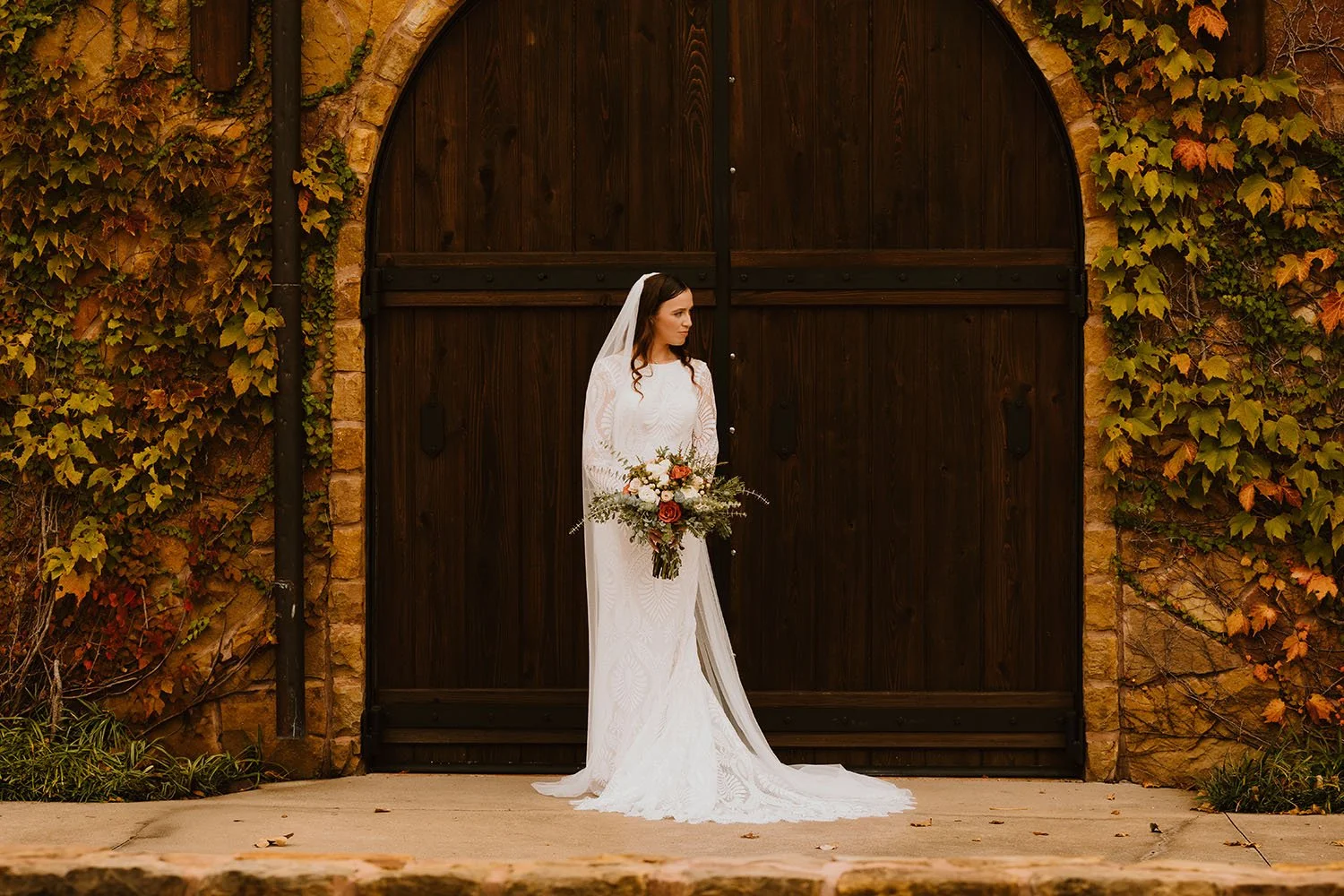 Bridal portrait in front of the Tuscan style building and rustic arched wooden door
