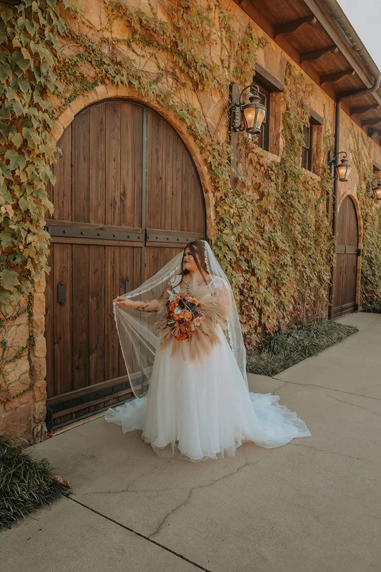 Bridal portrait in front of the Tuscan style building and rustic arched wooden door