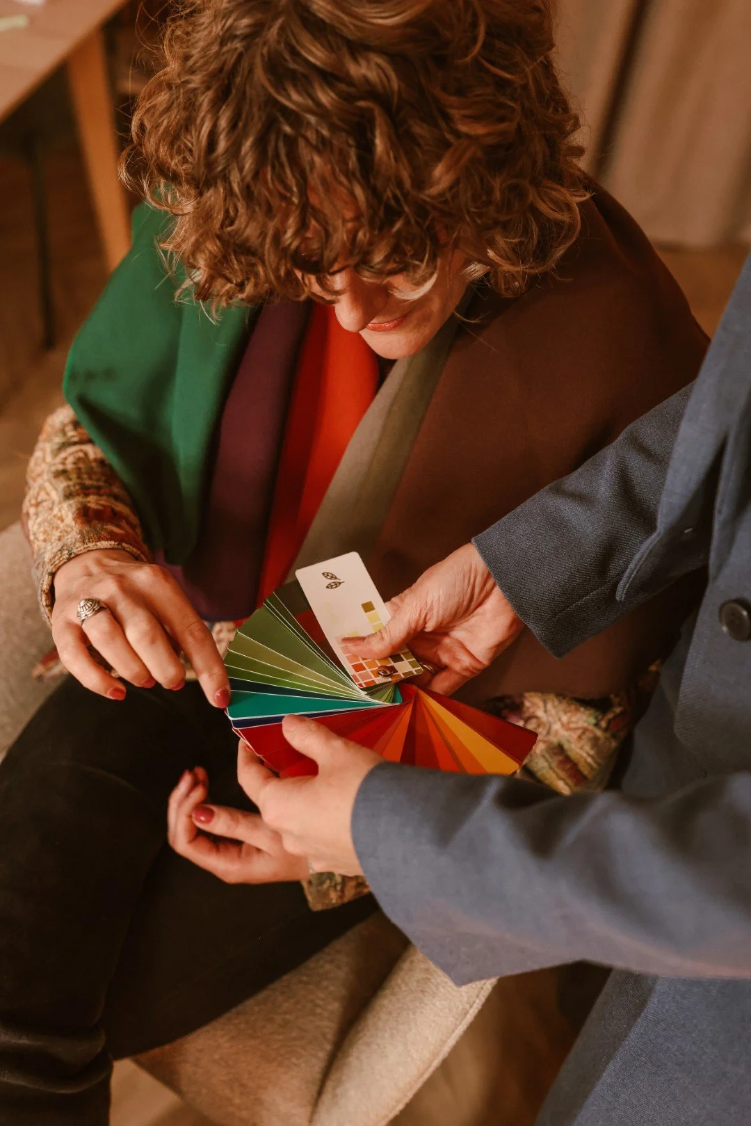 Twee mensen bekijken een kleurrant kleurenkaart en wallen een stukje.