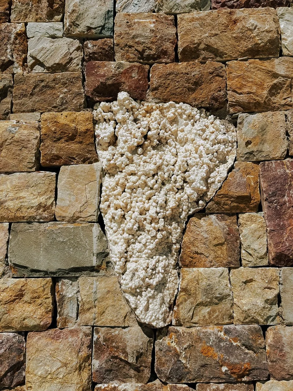 Muro de ladrillos con una parte de piedra.