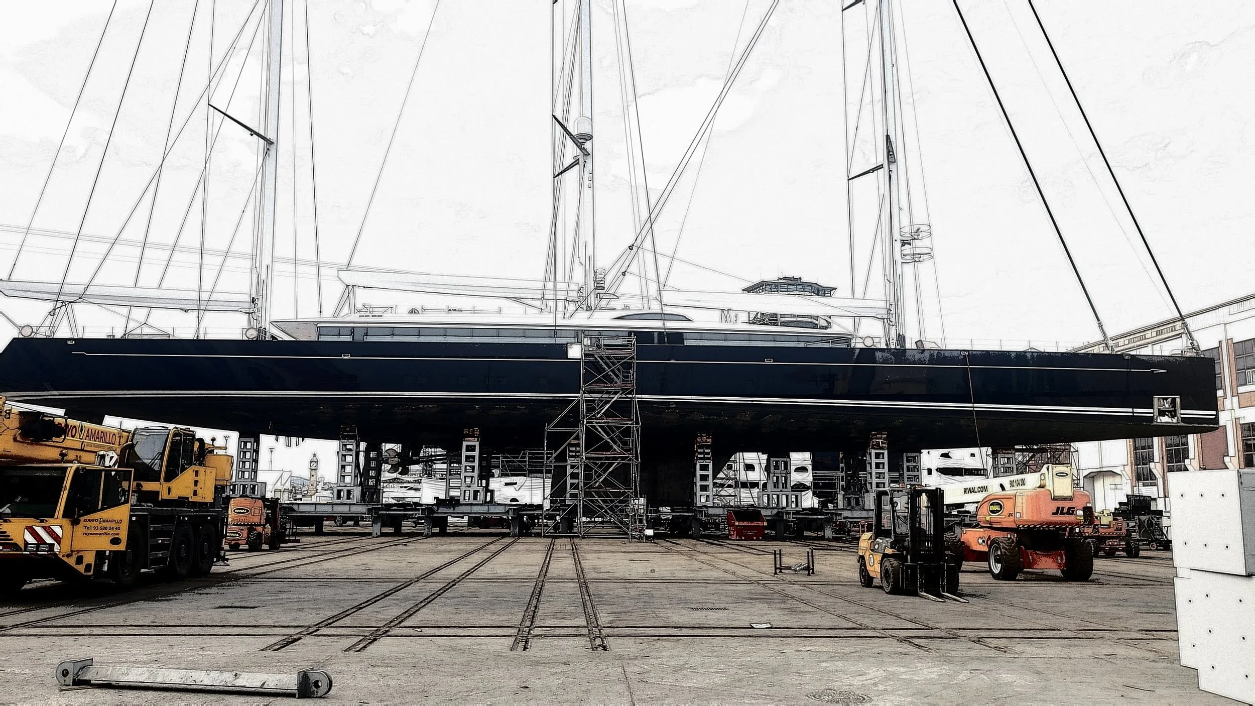 A luxury sailboat on dry dock with construction and maintenance equipment around it.