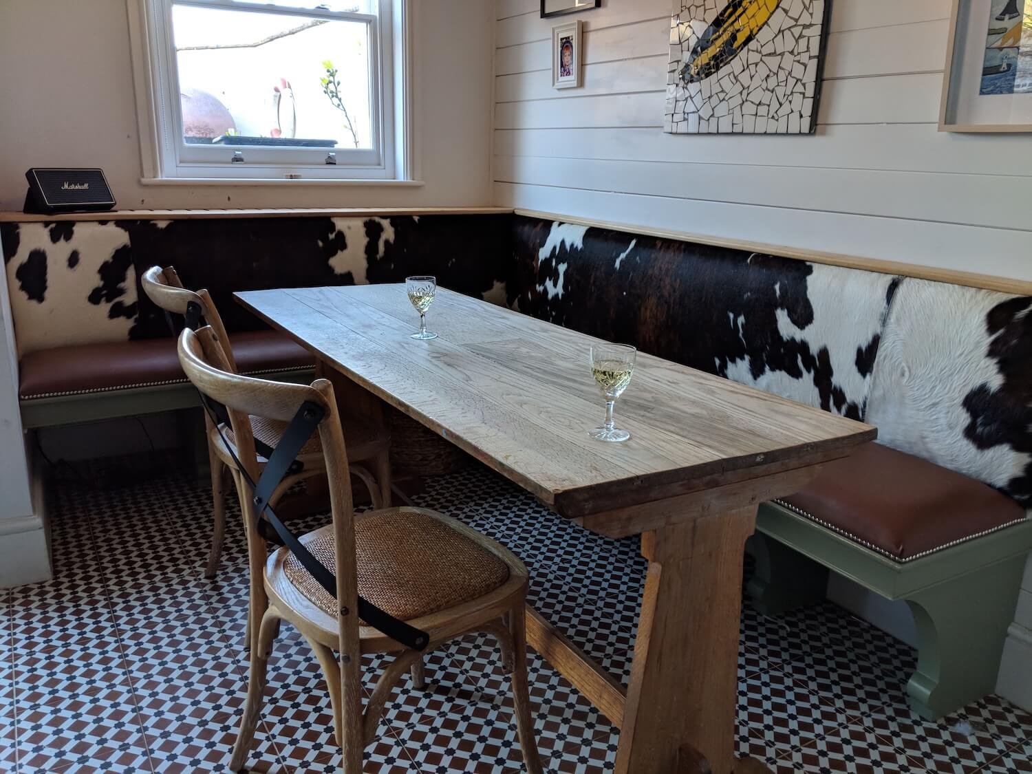 Rustic banquette dining nook with cowhide upholstery and wooden table